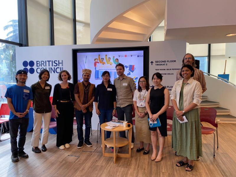 Group of people stood together in front of a presentation screen - team photo